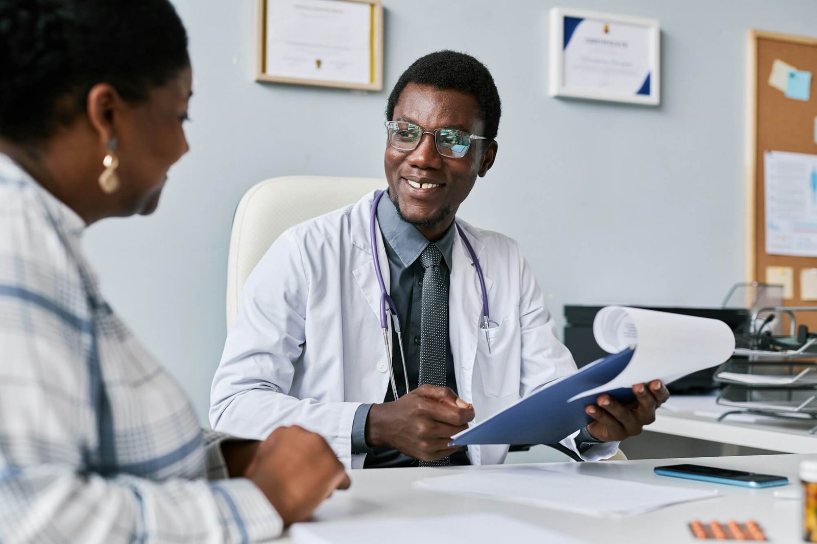 smiling-black-doctor-consulting-female-doctor-in-clinic.jpg